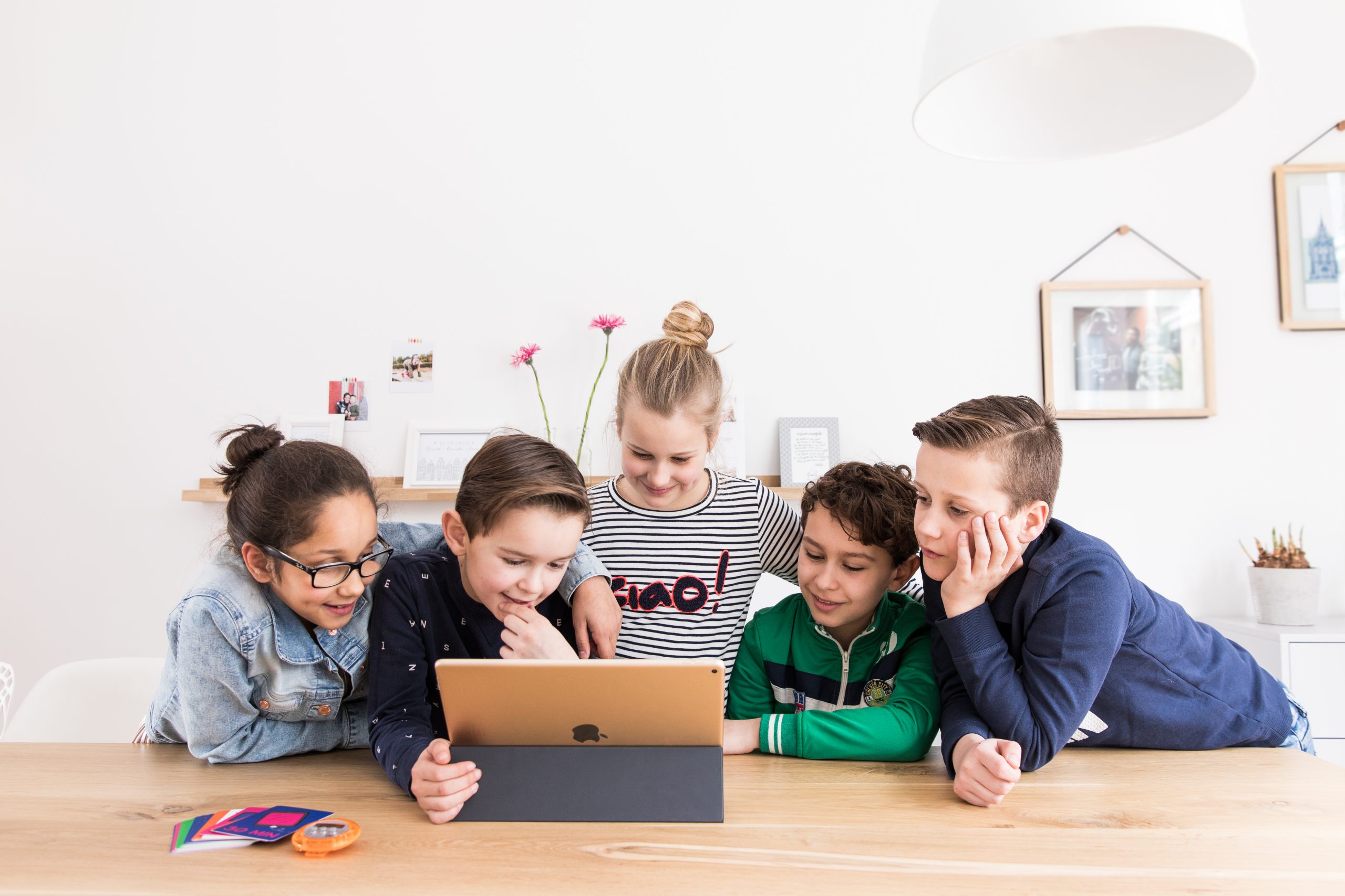 Vier Kinder an einem Tablet, mit Mytimingcards auf dem Tisch